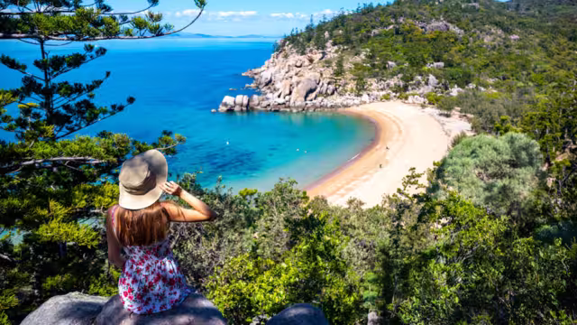 Traveller in sun hat looks out at Magnetic Island Beach