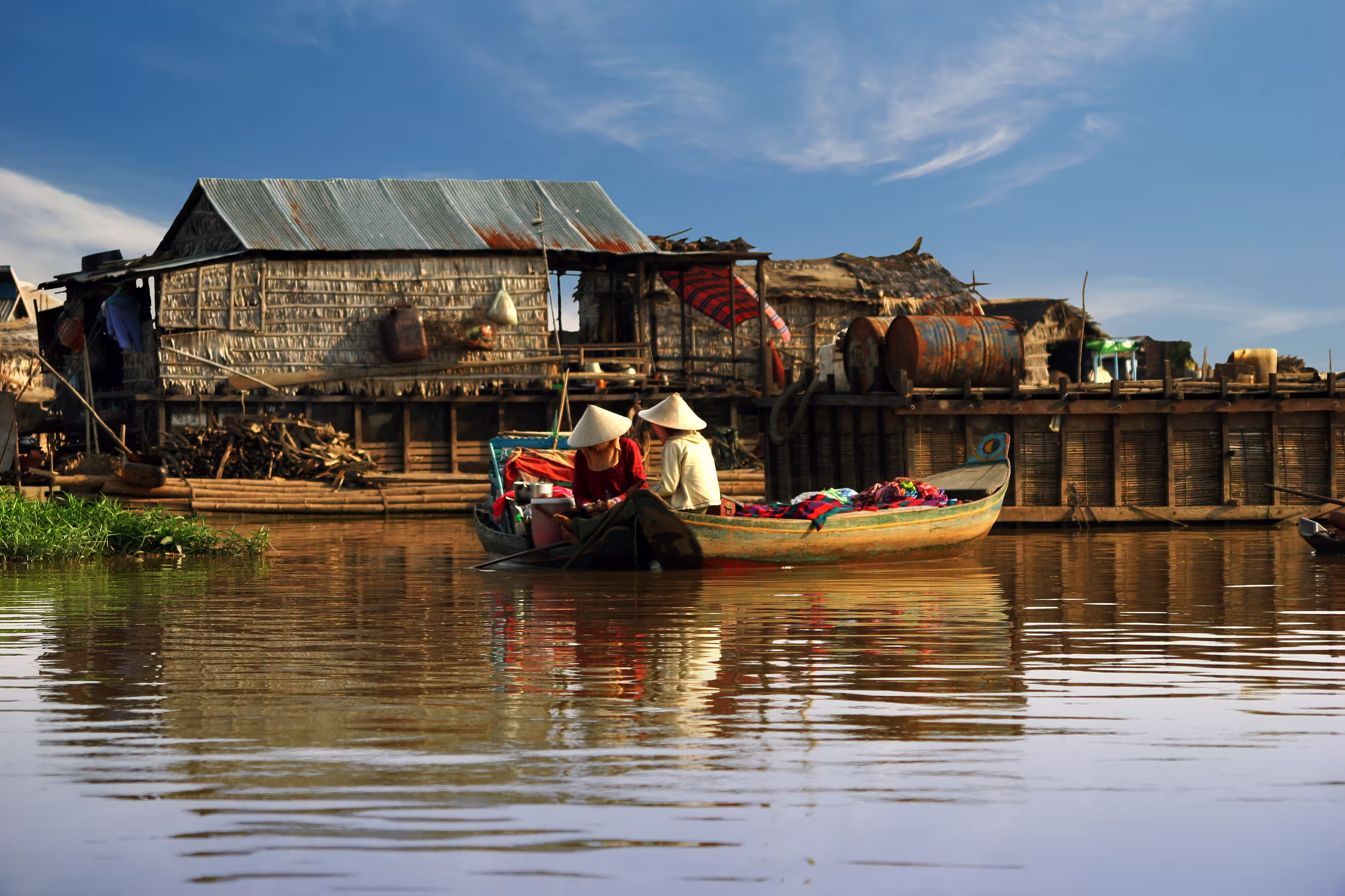 Cambodian women sail on a boat near the fishing village of Tonle Sap Lake