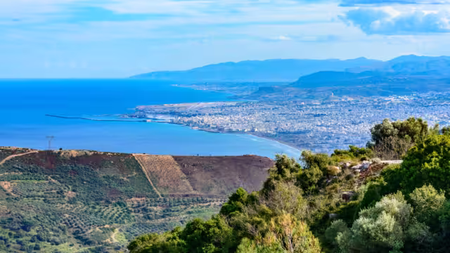 Panoramic skyline view of Mediterranean vacation destination Heraklion city, airport, popular resorts  Ammoudara,  Kokkini Hani, Gouves, Analipsi, and Lasithi mountains in background. Crete Greece.