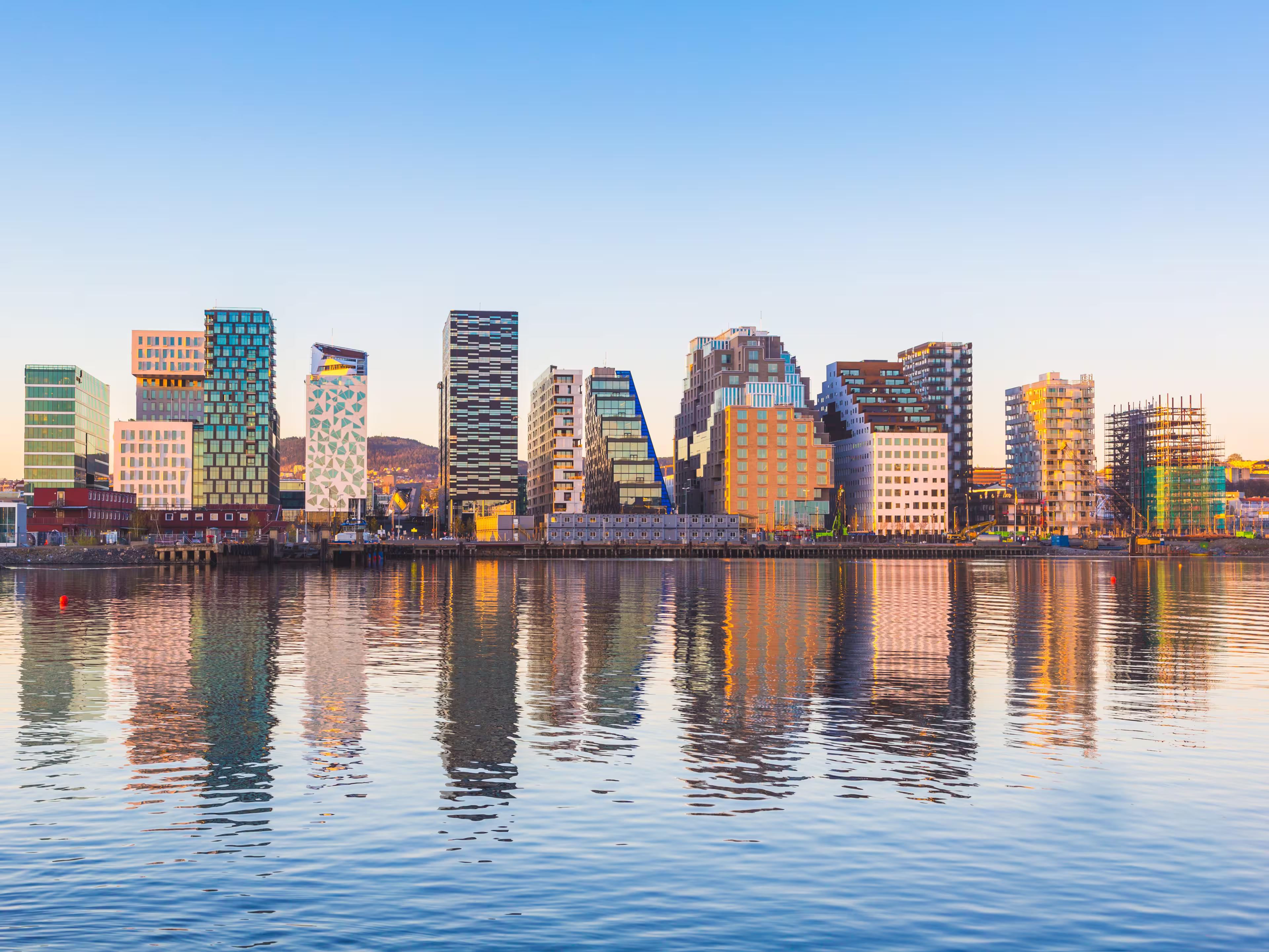 Modern buildings in Oslo, Norway, with their reflection into the water. These are some of the new buildings in the neighbourhood of Bjorvika. Concepts of travel and architecture.
