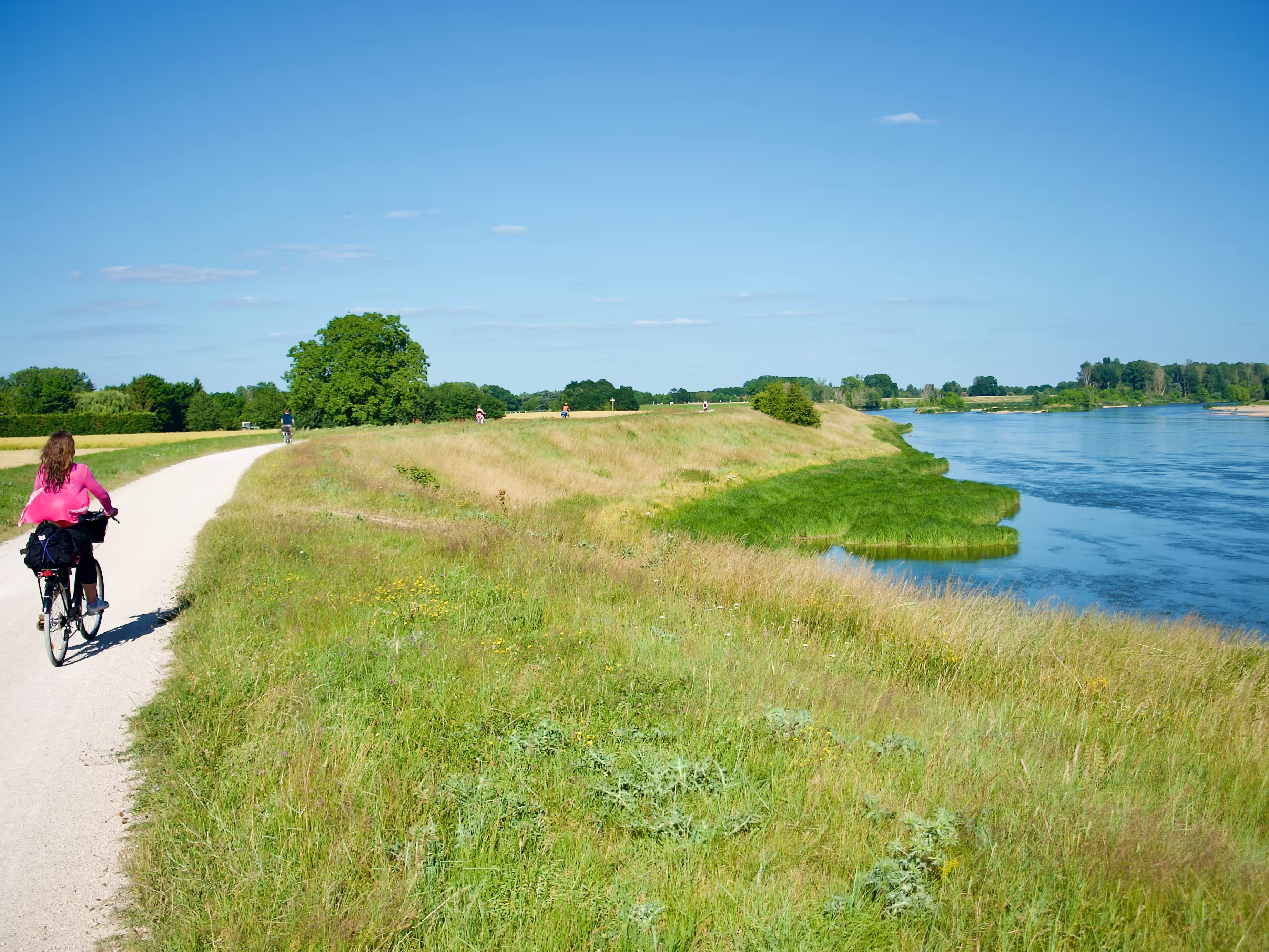 View on a path following the river Loire with cyclists in summer