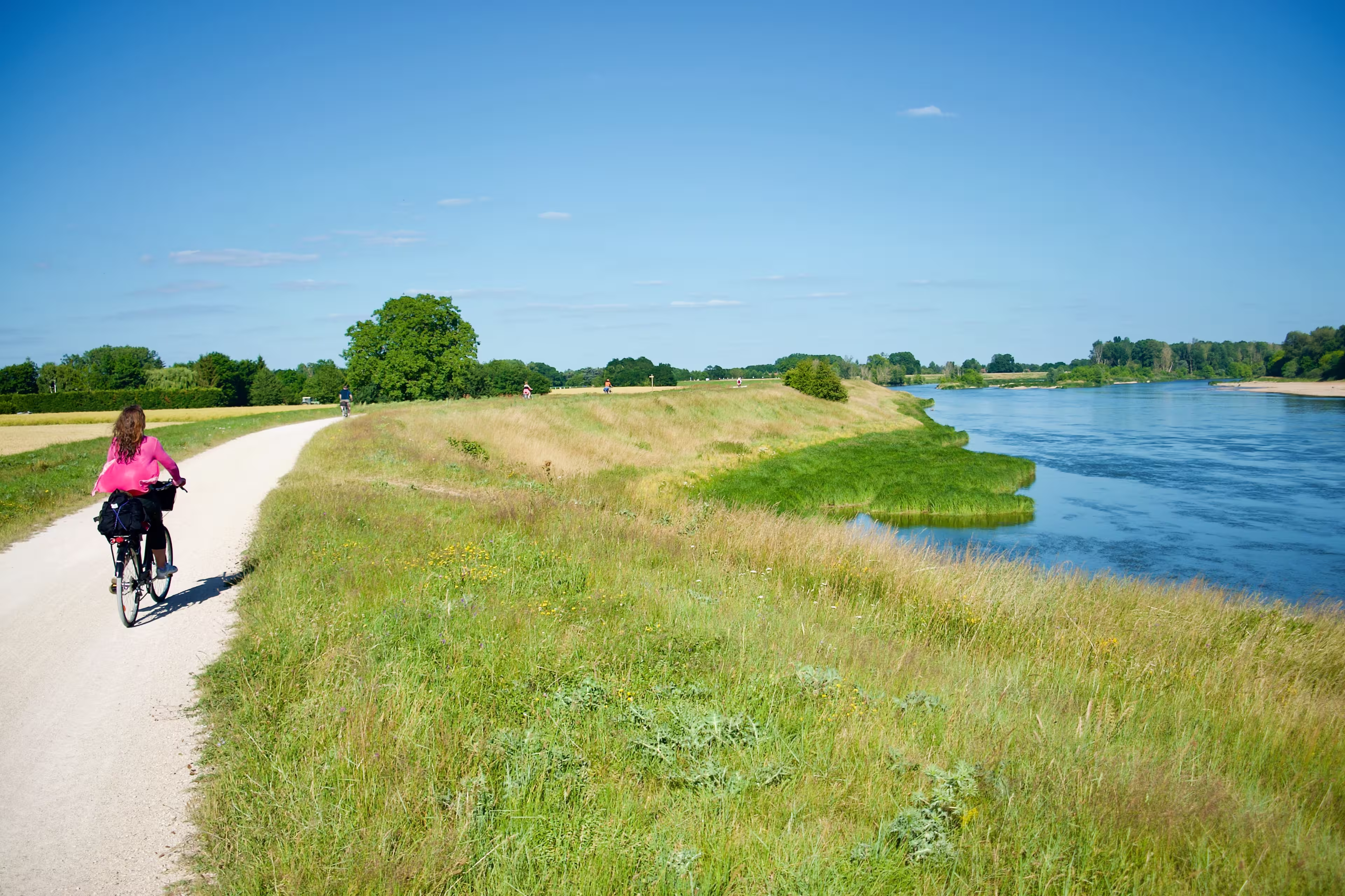 View on a path following the river Loire with cyclists in summer