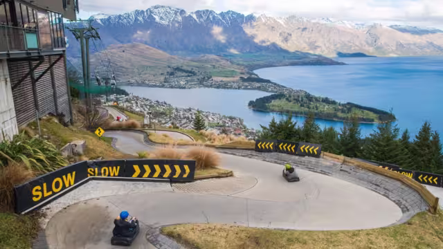 Travellers speeding downhill on luges in Queenstown, New Zealand