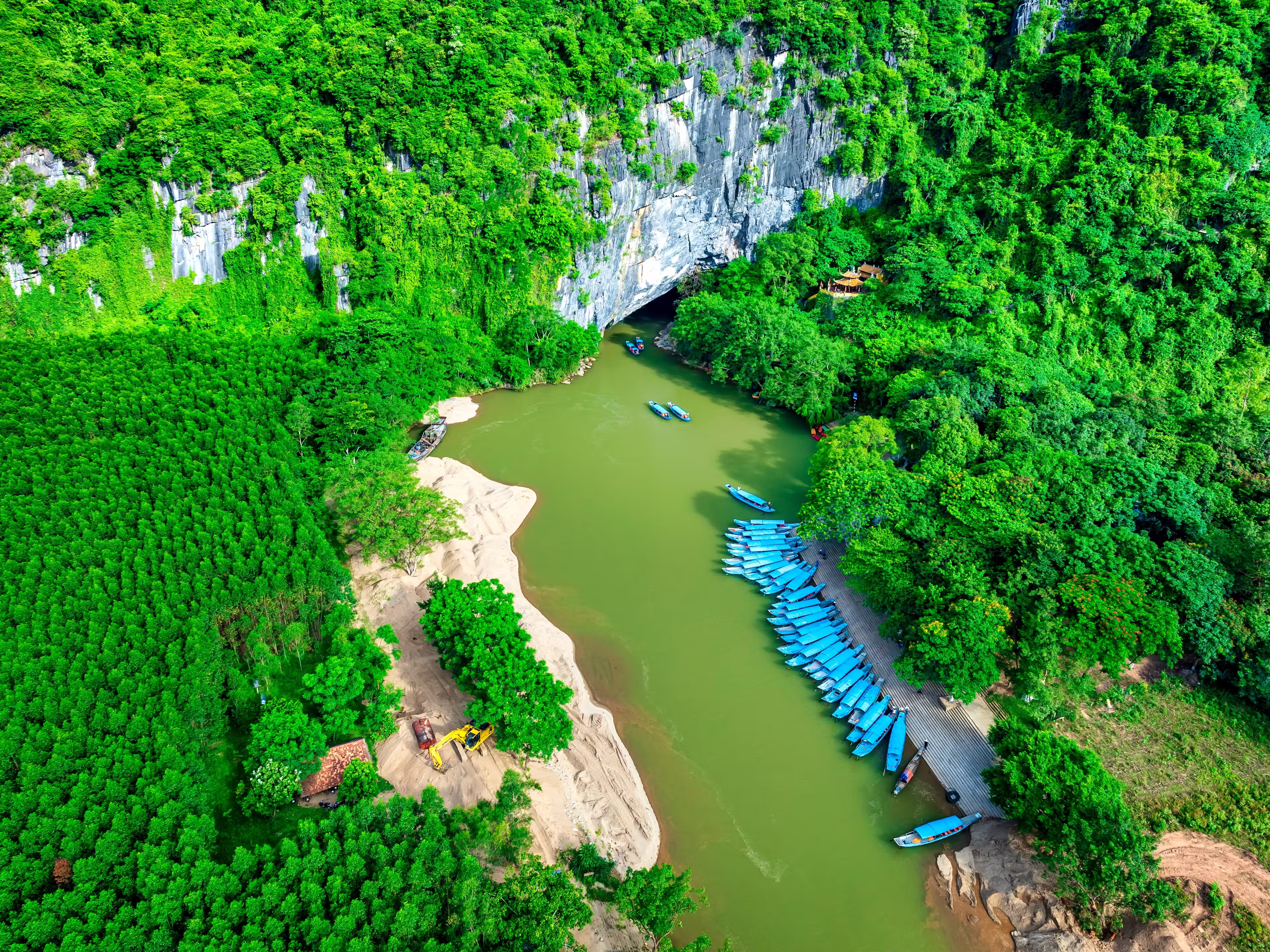 Aerial view of Scenic the Son River from Phong Nha Cave at Phong Nha-Ke Bang National Park in Vietnam. Underground part of the amazing subterranean river. Tourist boat leaving the wet cave.