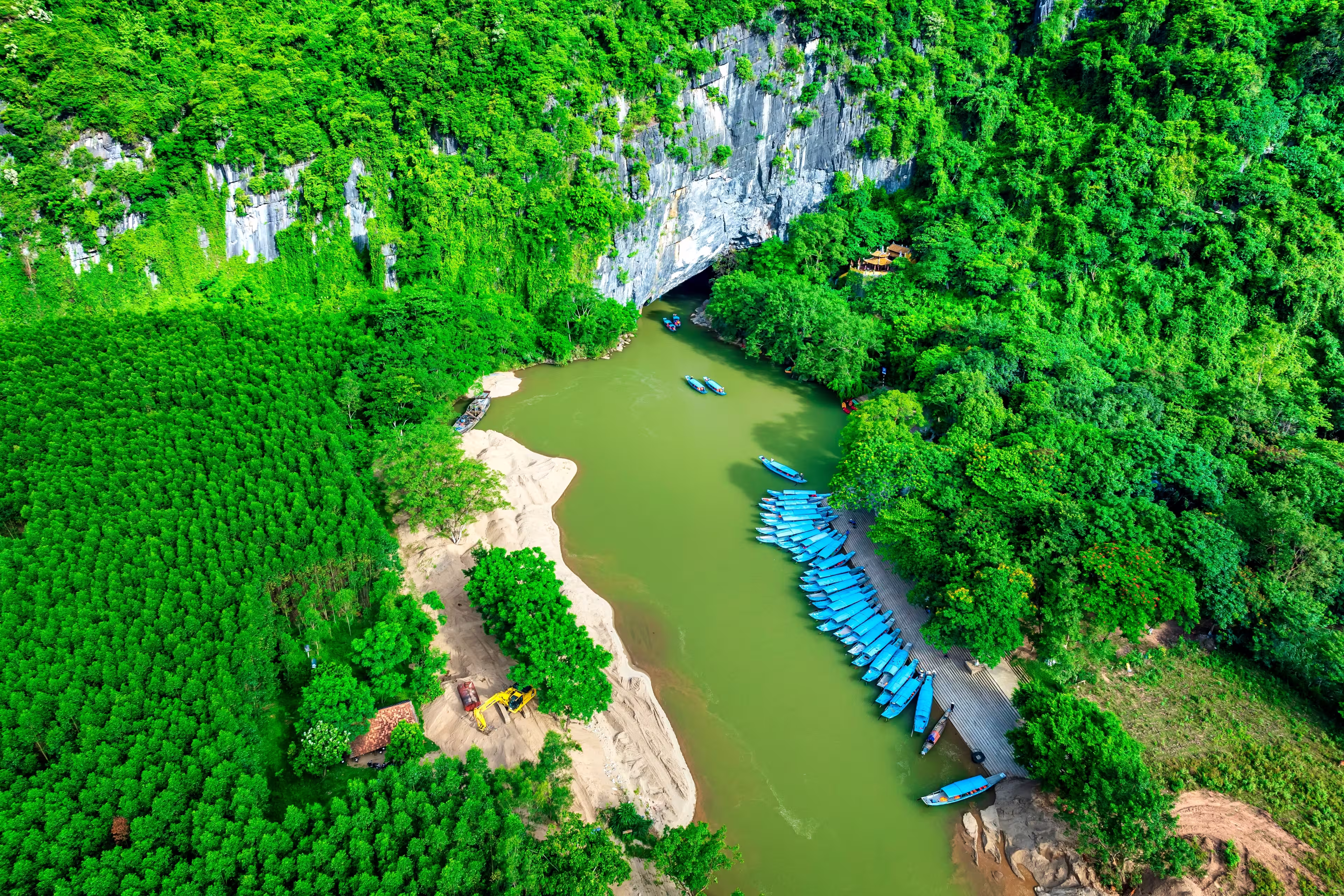 Aerial view of Scenic the Son River from Phong Nha Cave at Phong Nha-Ke Bang National Park in Vietnam. Underground part of the amazing subterranean river. Tourist boat leaving the wet cave.