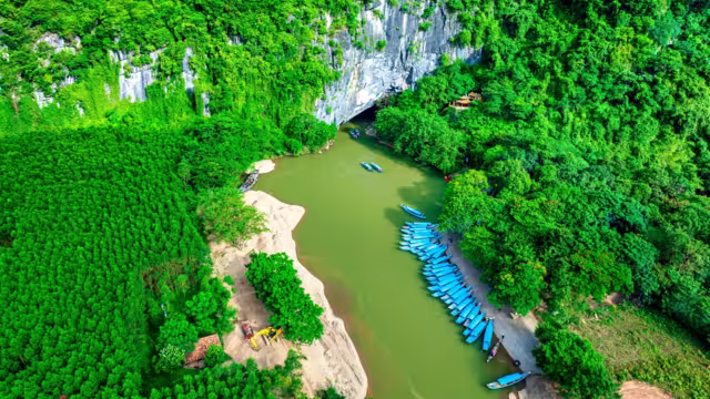 Aerial view of Scenic the Son River from Phong Nha Cave at Phong Nha-Ke Bang National Park in Vietnam. Underground part of the amazing subterranean river. Tourist boat leaving the wet cave.
