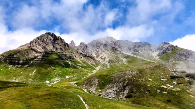 St. Anton am Arlberg hiking mountains grass wood and rocky terrain cloudy sky sunlight