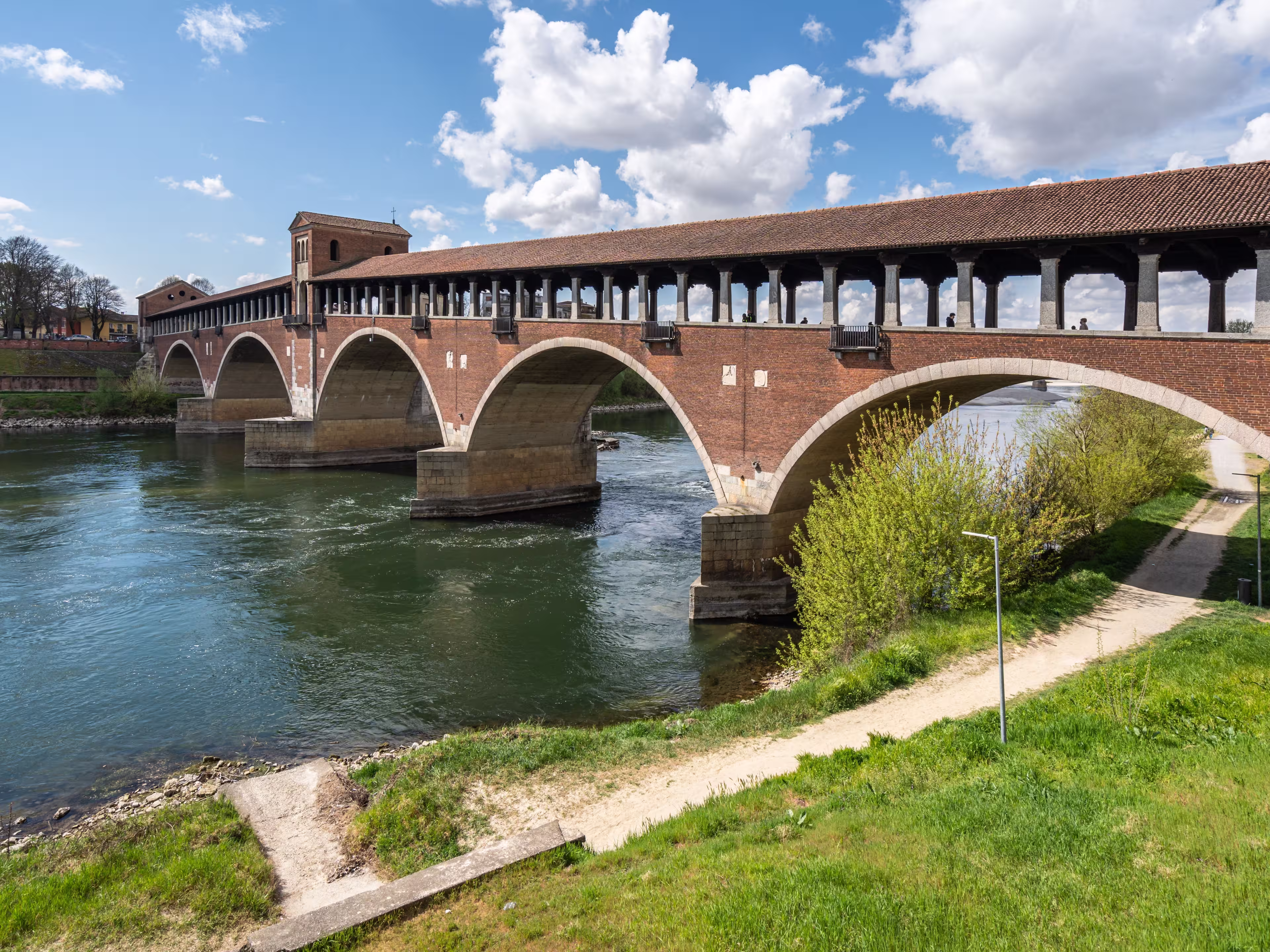 The Ponte Coperto (Covered Bridge) in Pavia, a brick arch bridge over the Ticino River, Lombardy, Italy