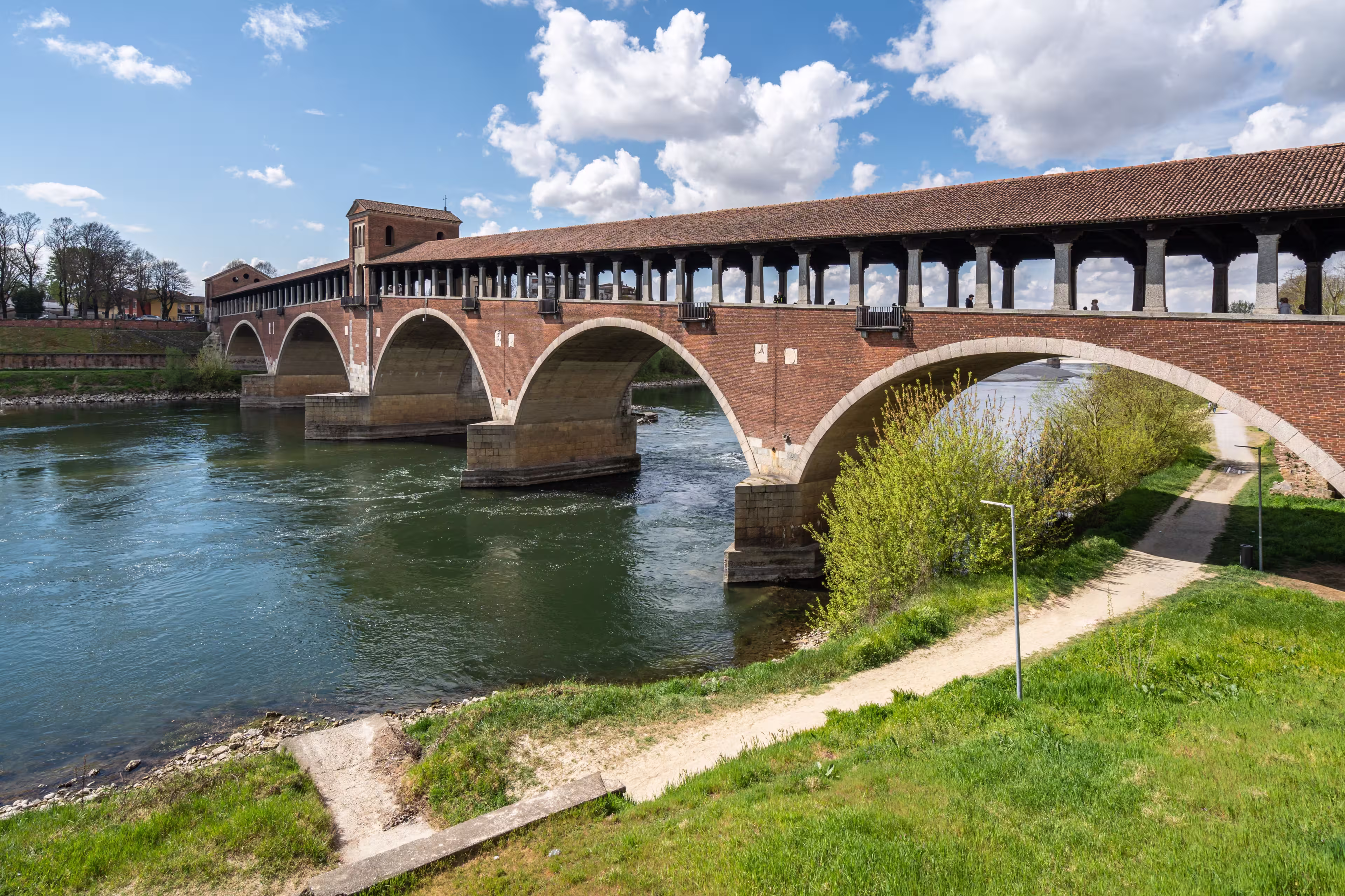 The Ponte Coperto (Covered Bridge) in Pavia, a brick arch bridge over the Ticino River, Lombardy, Italy