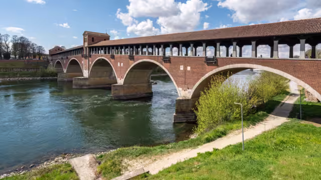 The Ponte Coperto (Covered Bridge) in Pavia, a brick arch bridge over the Ticino River, Lombardy, Italy